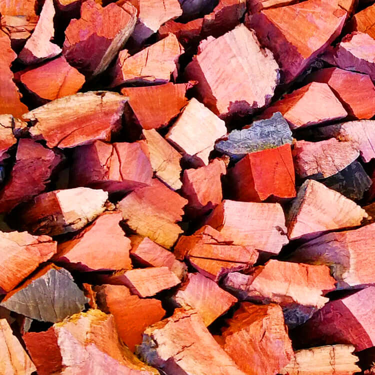 Close-up of premium Red Gum firewood (Rooi Bloekom Hout) showing deep red and brown hues in dense hardwood texture - perfect for braai and fireplace in Cape Town.
