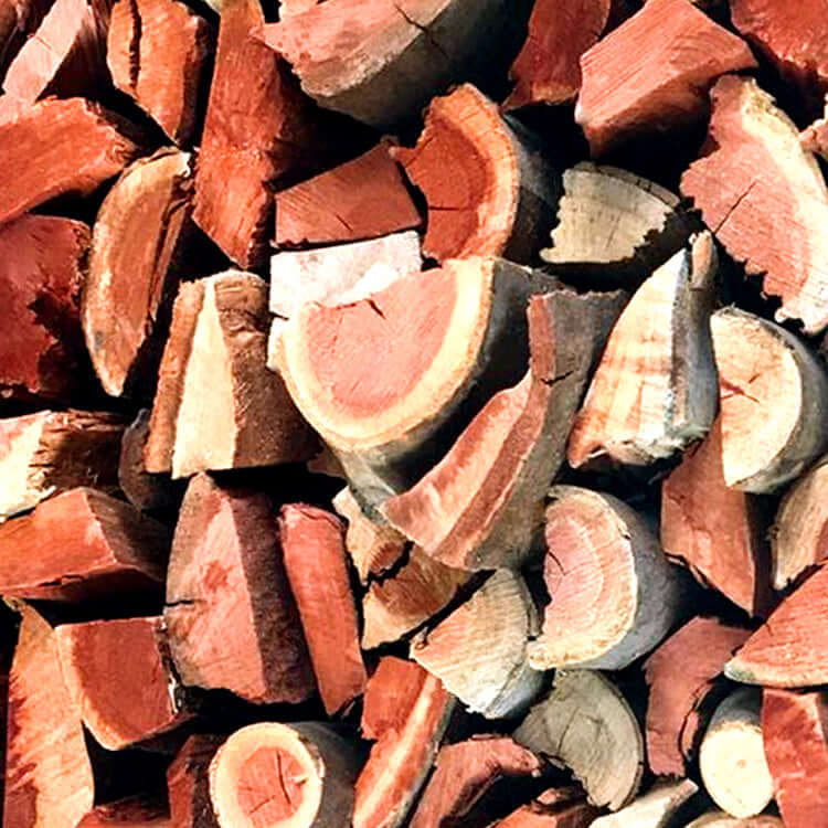 Macro shot of Red Gum wood bulk pieces highlighting rich red and brown colors with distinctive greyish cream textured bark