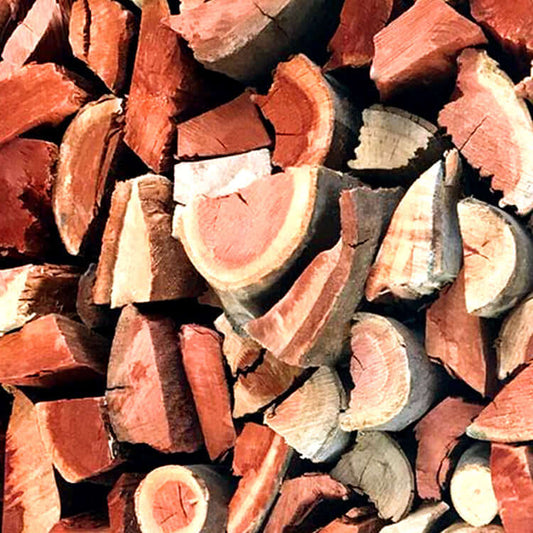 Macro shot of Red Gum wood bulk pieces highlighting rich red and brown colors with distinctive greyish cream textured bark